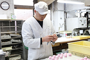 工場でお菓子を作る丸山さん